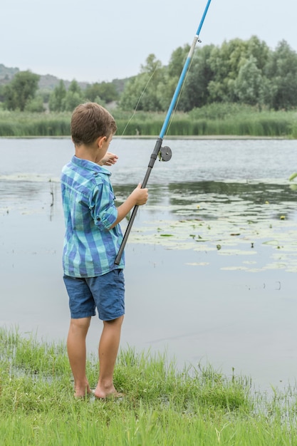 Little boy is fishing on the river