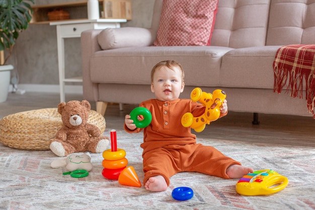 A little boy is sitting playing with toys on the floor of the house