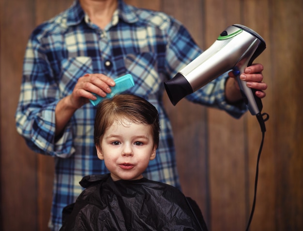 A little boy is trimmed in the hairdresser's bright emotions on his face