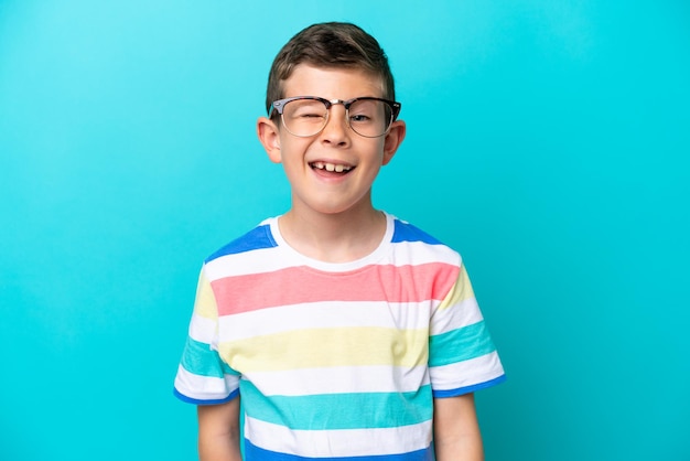 Little boy isolated on blue background With glasses and happy expression