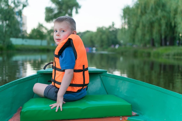 A little boy in a life jacket in a boat