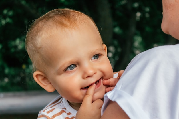 Little boy looks over his mothers shoulder