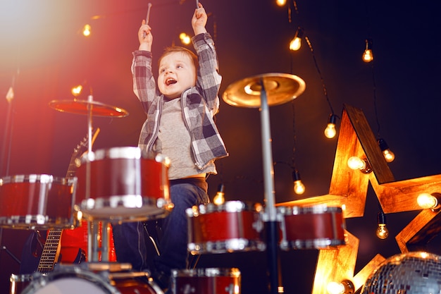 Little boy playing the drums on the stage