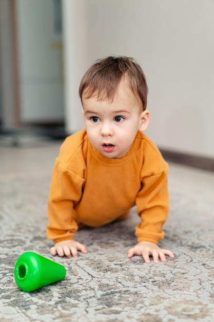 Little boy playing on the floor in home Small child with colourful toy