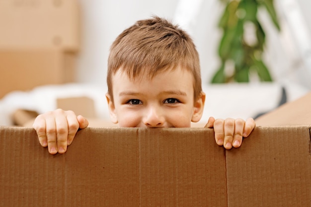 Little boy playing inside a moving box on a moving day