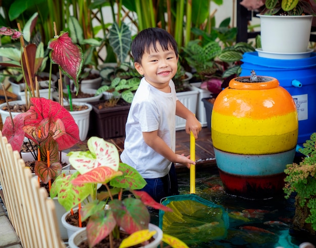 Little boy playing in a koi pond