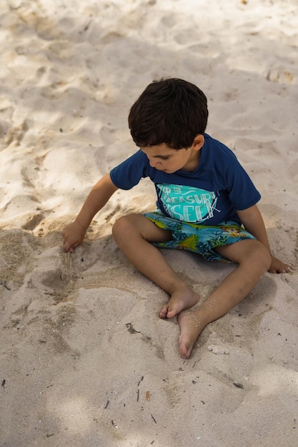 Little boy playing in the sand on the beach