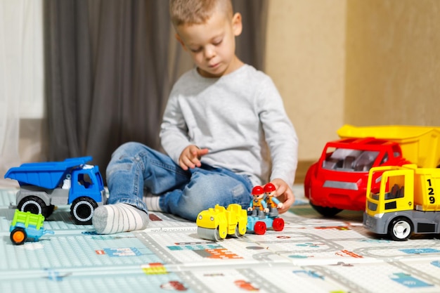 Little boy playing with car and truck toys