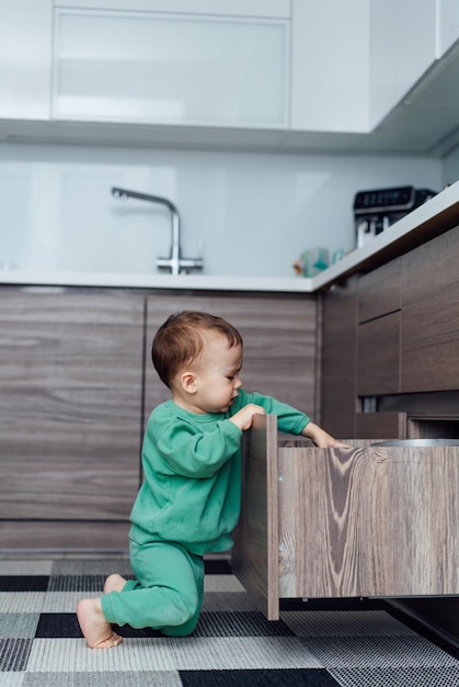 Little boy playing with shelves Indoor playful kid sitting on the floor