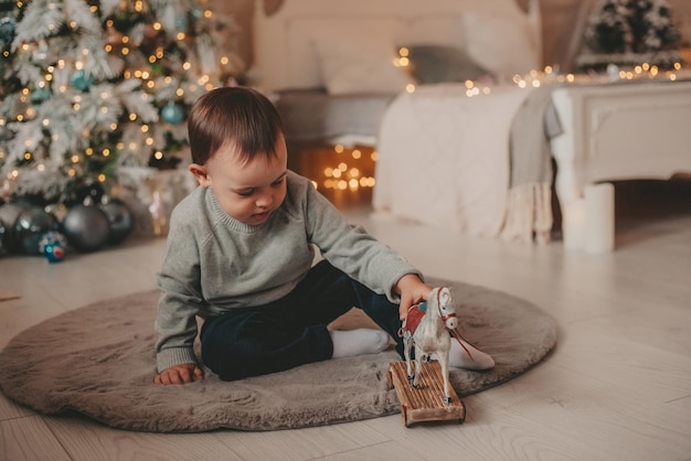 little boy playing with toys in christmas decorations