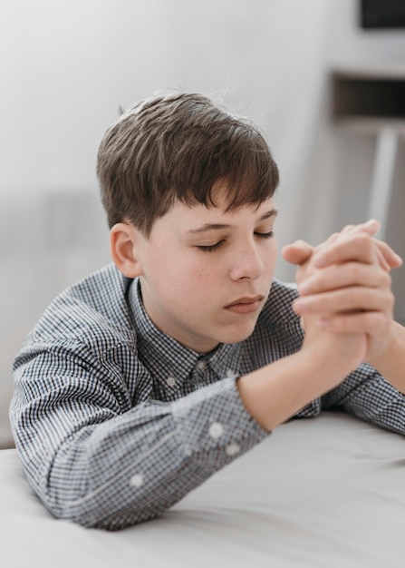 Little boy praying on his knees