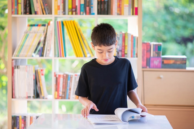 Little boy reading book in the library