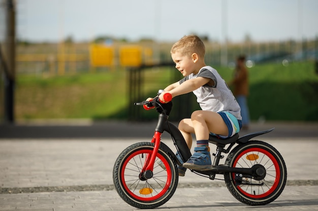 Little boy riding a bike in a city park