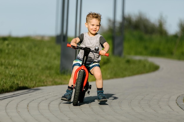 Little boy riding a bike in a city park