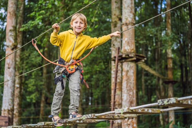 Little boy in a rope park Active physical recreation of the child in the fresh air in the park Training for children