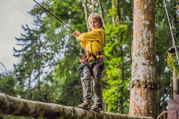 Little boy in a rope park Active physical recreation of the child in the fresh air in the park Training for children