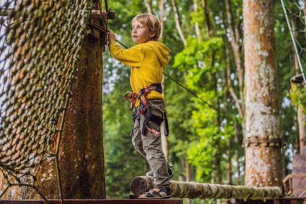 Little boy in a rope park Active physical recreation of the child in the fresh air in the park Training for children