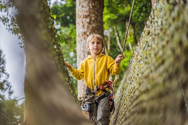 Little boy in a rope park Active physical recreation of the child in the fresh air in the park Training for children