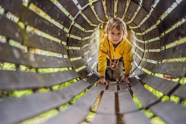 Little boy in a rope park Active physical recreation of the child in the fresh air in the park Training for children