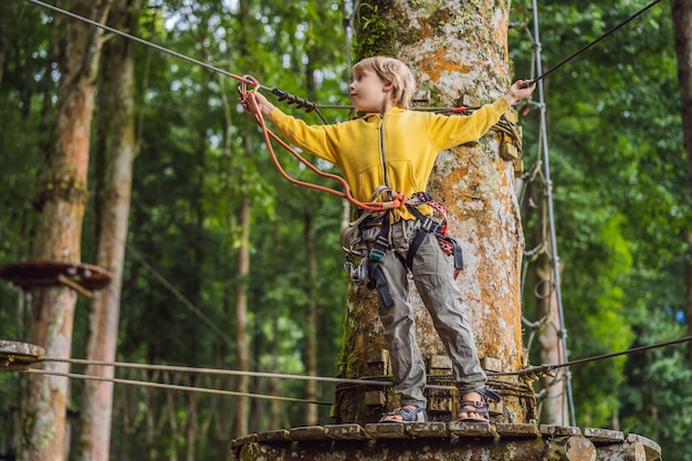 Little boy in a rope park Active physical recreation of the child in the fresh air in the park Training for children