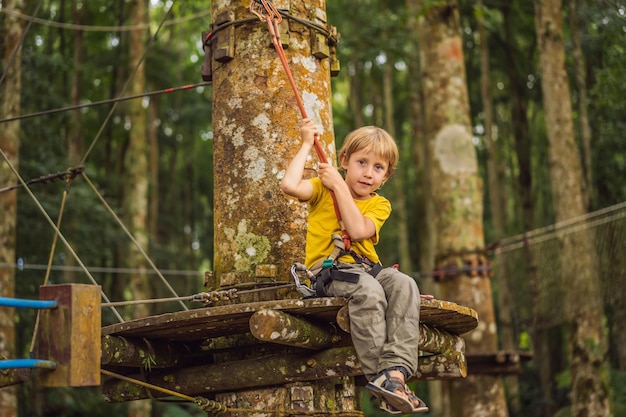 Little boy in a rope park Active physical recreation of the child in the fresh air in the park Training for children