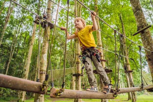 Little boy in a rope park Active physical recreation of the child in the fresh air in the park Training for children