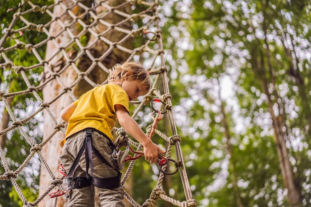 Little boy in a rope park Active physical recreation of the child in the fresh air in the park Training for children