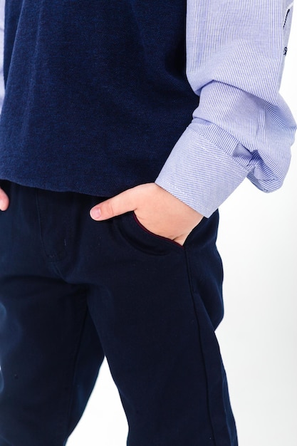 Little boy in school uniform isolated on white background Pants with pockets shown closeup Vertical photo