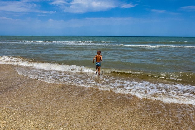 A little boy on the shore of the Caspian Sea with shells Dagestan Russia 2021