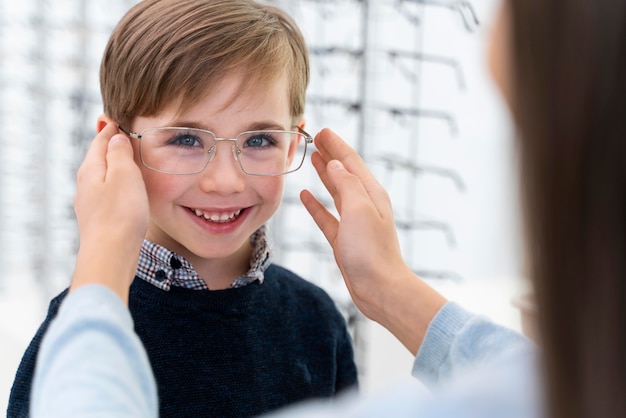 Little boy and sister in store trying on glasses