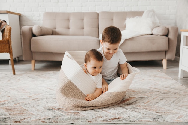 A little boy sits in a wicker basket and laughs Happy childhood concept