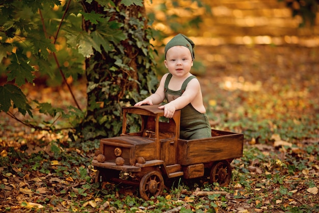 Little boy sitting in wooden childrens toy car