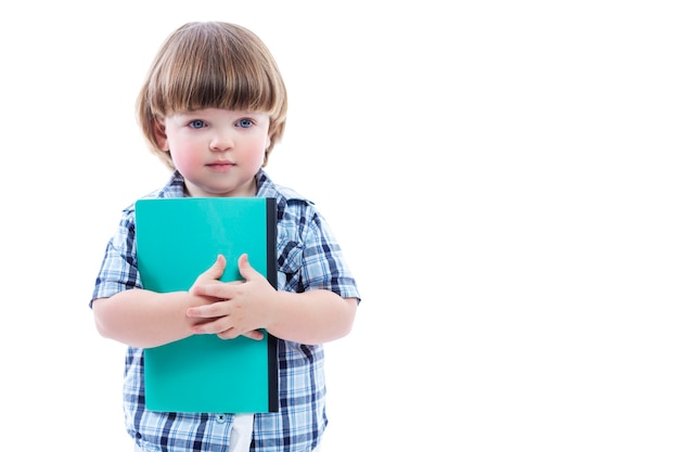 A little boy stands with a notebook in his hands A child in a checkered shirt and a funny haircut Learning and curiosity at a young age Isolated on a white background Space for text