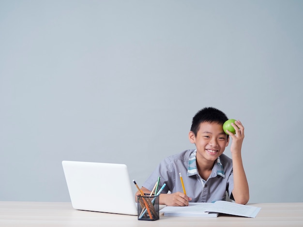 Little boy studying online with laptop. Distance learning during COVID-19 pandemic