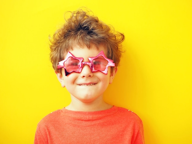 Little boy in sunglasses in shape of star makes face