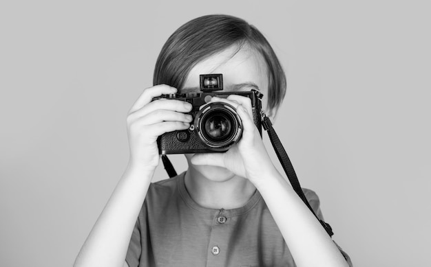 Little boy on a taking a photo using a vintage camera Child in studio with professional camera Boy using a cameras Baby boy with camera Cheerful smiling child holding a cameras