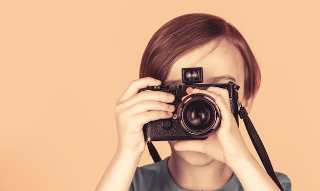 Little boy on a taking a photo using a vintage camera Child in studio with professional camera Boy using a cameras Baby boy with camera Cheerful smiling child holding a cameras