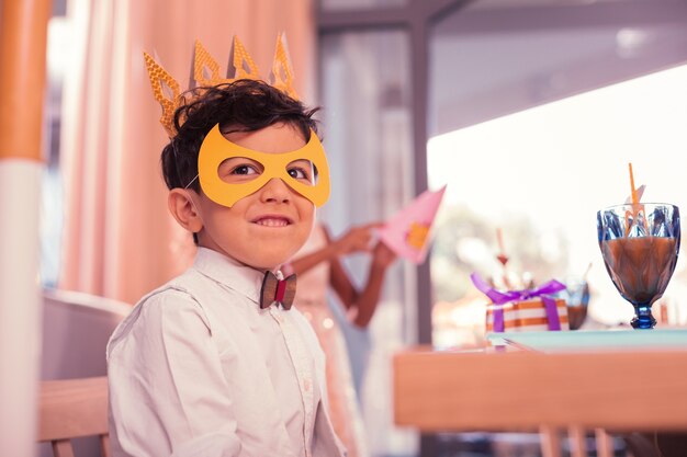 Photo little boy wearing cute mask while being at the birthday party