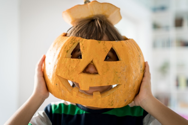 Little boy wearing halloween pumpkin mask