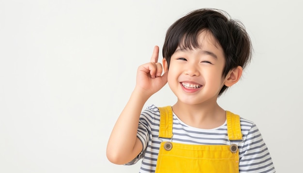 a little boy wearing a yellow apron points to the camera