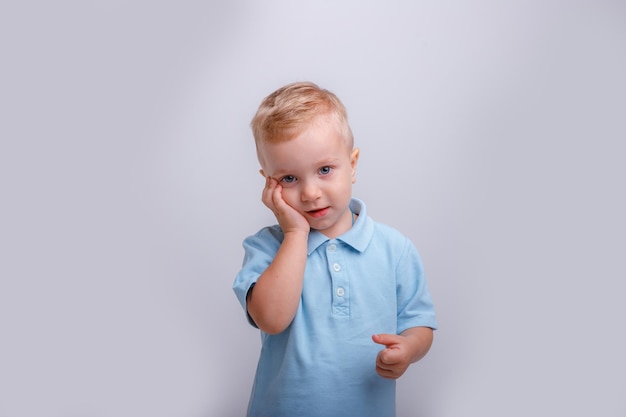 Little boy on a white background in a blue shirt studio