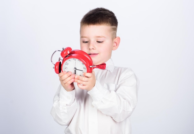 Little boy with alarm clock. Time to relax. tuxedo kid. Happy childhood. Party time. Businessman. Formal wear. happy child with retro clock in bow tie. Time management. Morning. Morning vibes.