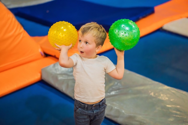 Little boy with a ball on trampolines