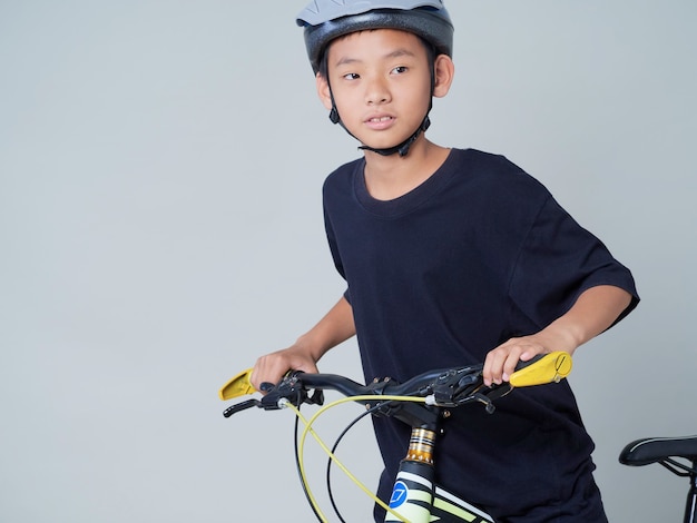 Little boy with bicycle on light background