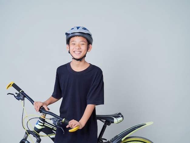 Little boy with bicycle on light background