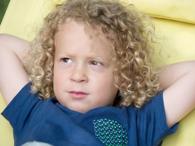 Little boy with curly blond hair, outside