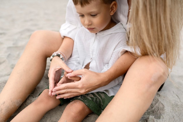 Photo little boy with his mother at the sea playing and having fun