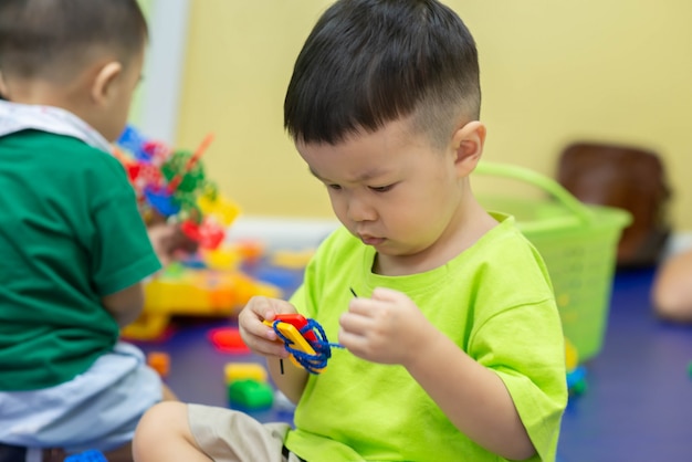 Little boys playing toy together in the room 