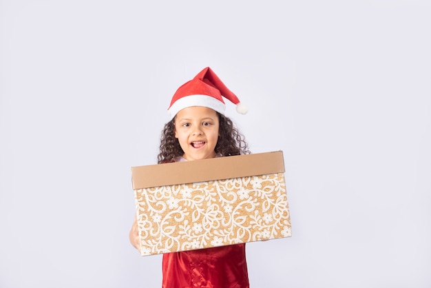 Little Brazilian girl dressed with christmas costume holding a gift box