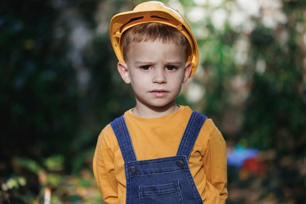 Little builder in helmet child dressed as a workman builder portrait little builder in hardhats